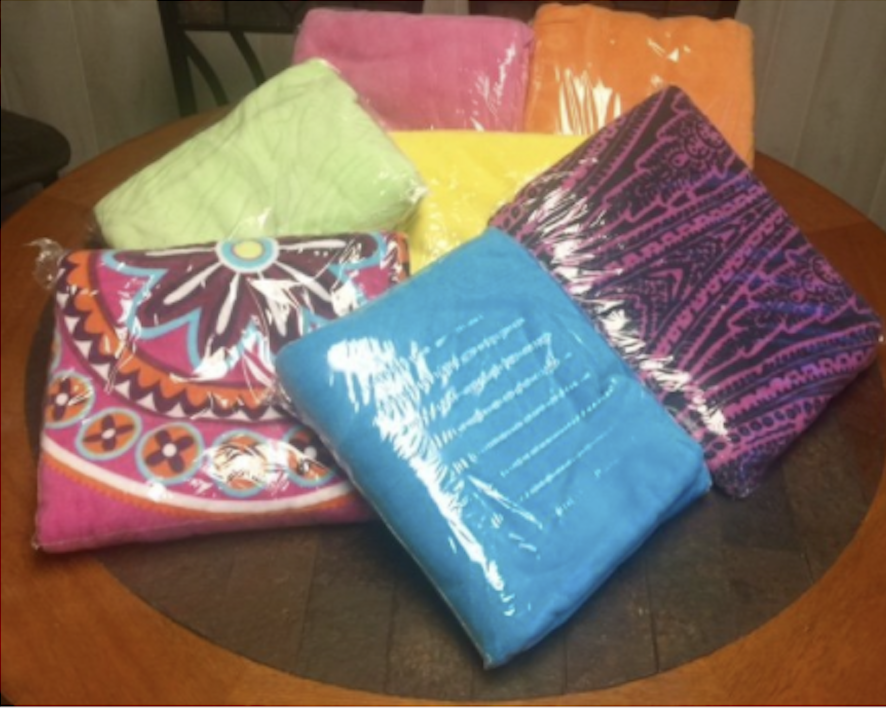 An image displaying an assortment of different colored towels packaged and ready for rental from Sharon's Linens & Beach Rentals